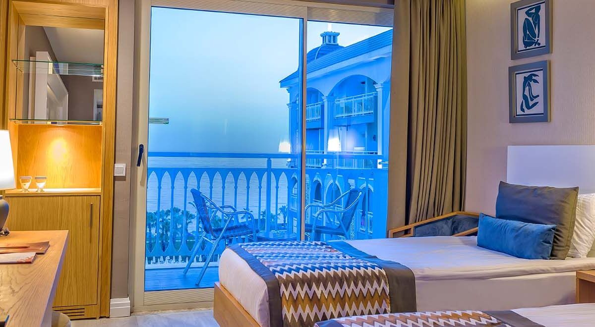 Doppelzimmer mit Sicht auf Bett mit Balkon und Sicht auf das Meer.